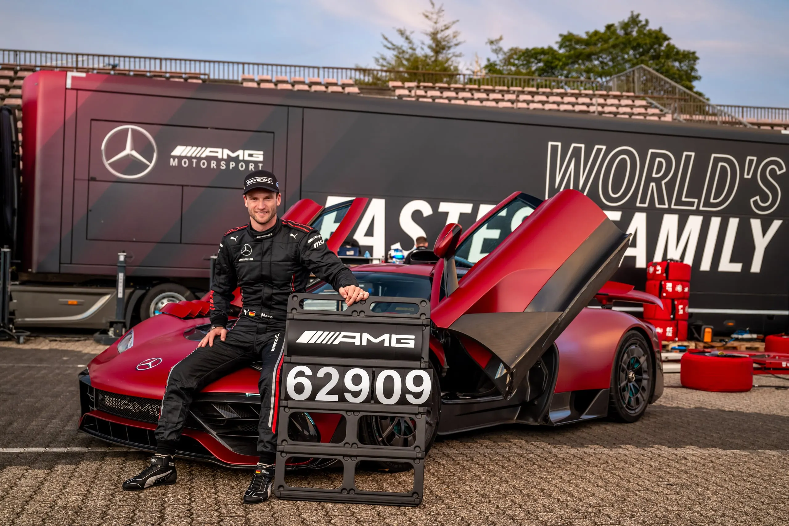 Rennfahrer sitzt am AMG ONE vor dem Motorsport-Truck