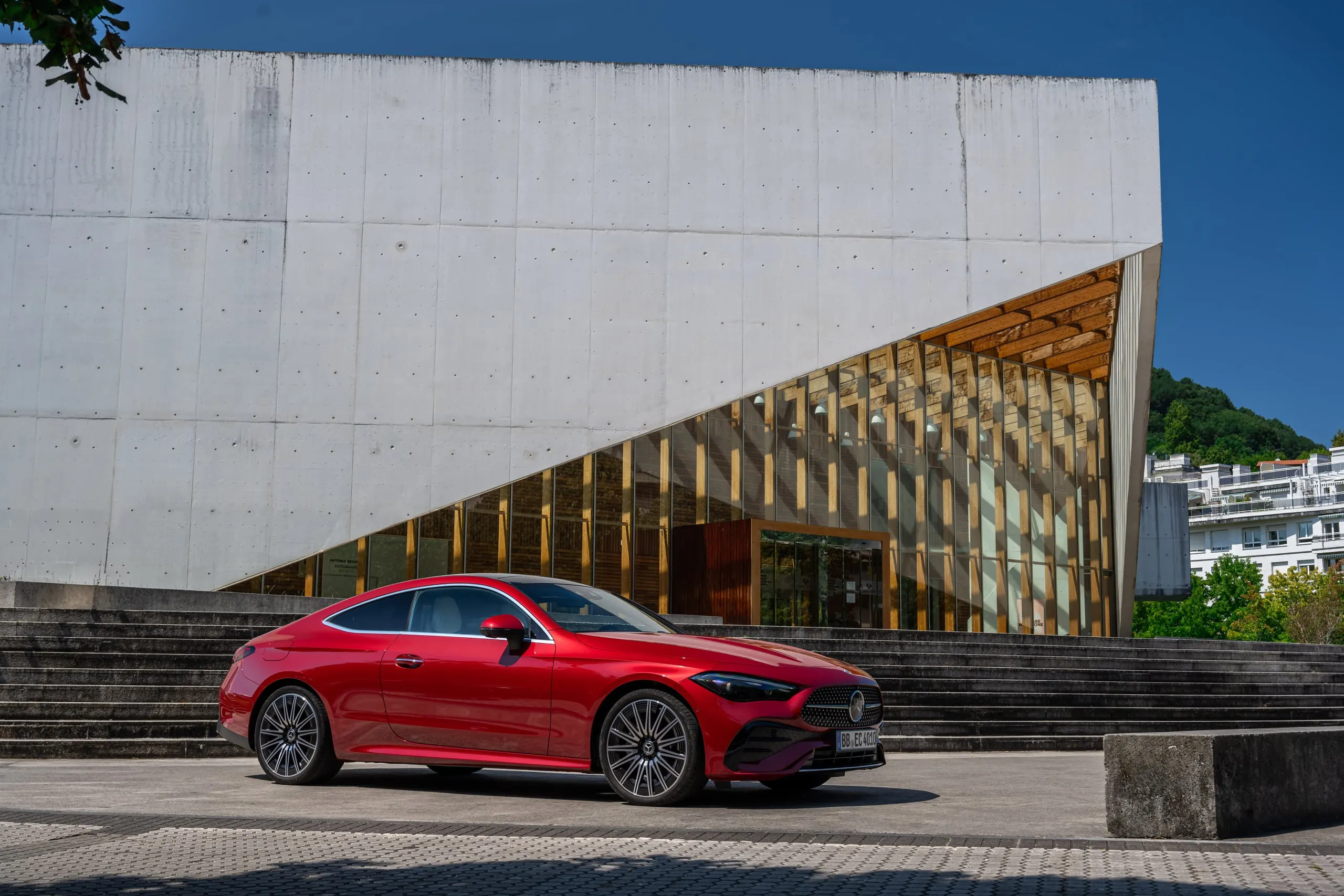 Rotes CLE Coupé vor moderner Architektur