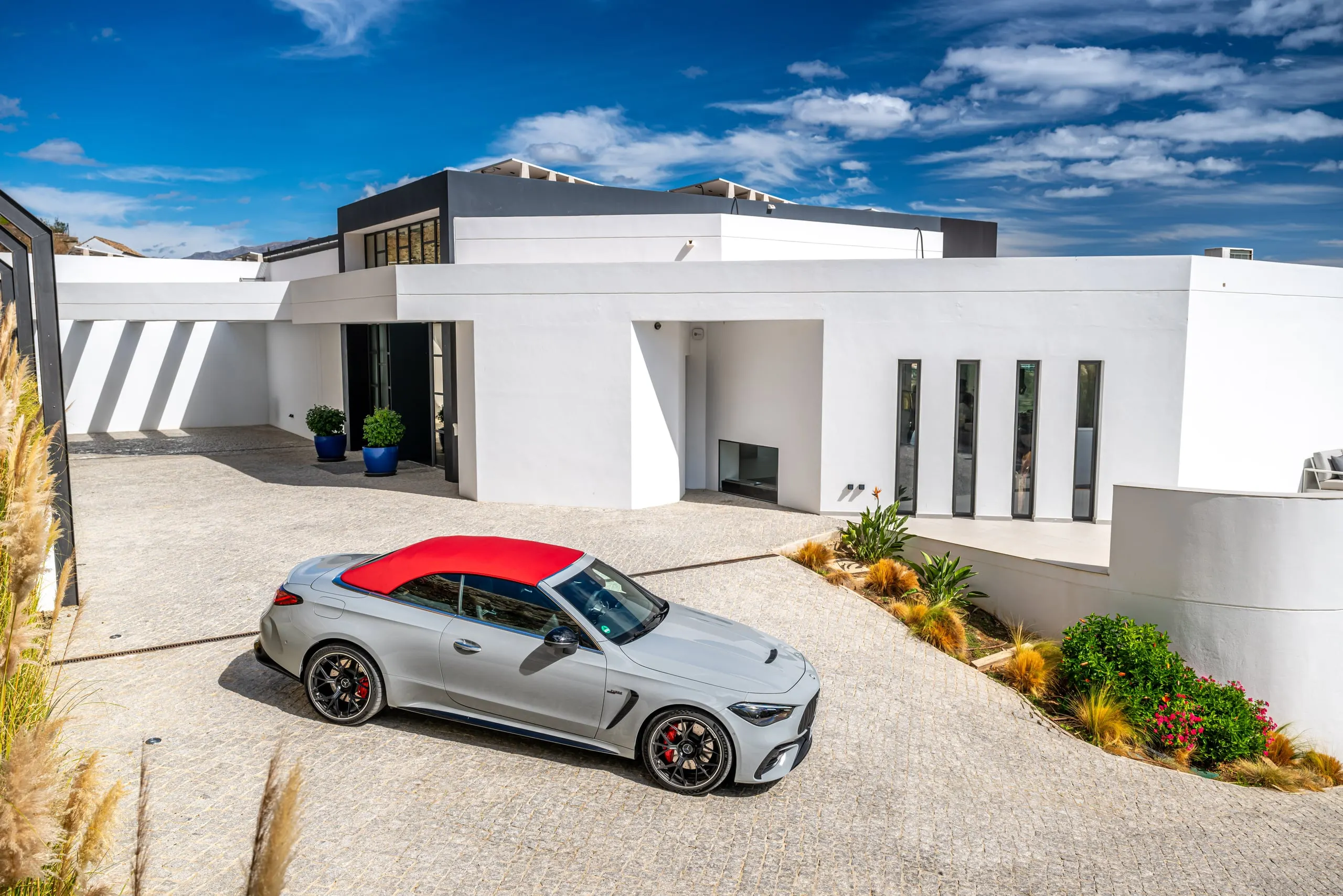 CLE 53 Cabriolet mit rotem Verdeck vor moderner weißer Villa