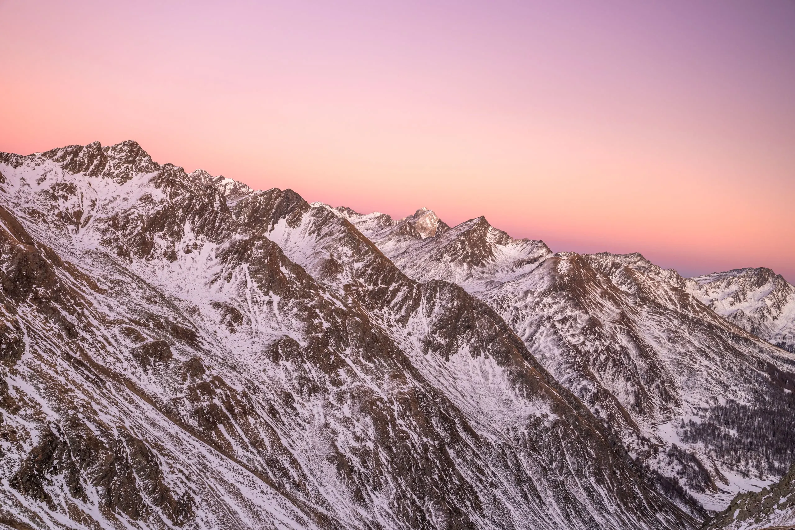 Verschneite Gipfel im Alpenglühen
