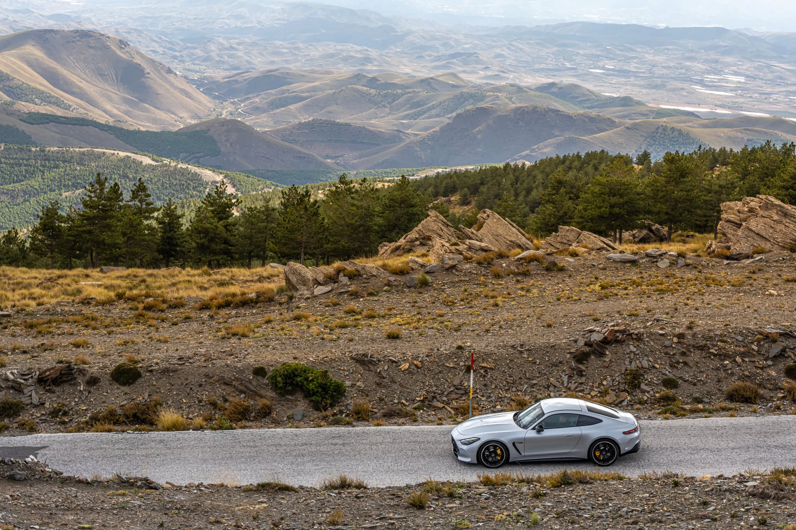 AMG GT auf einer Bergstraße vor weiter Landschaft