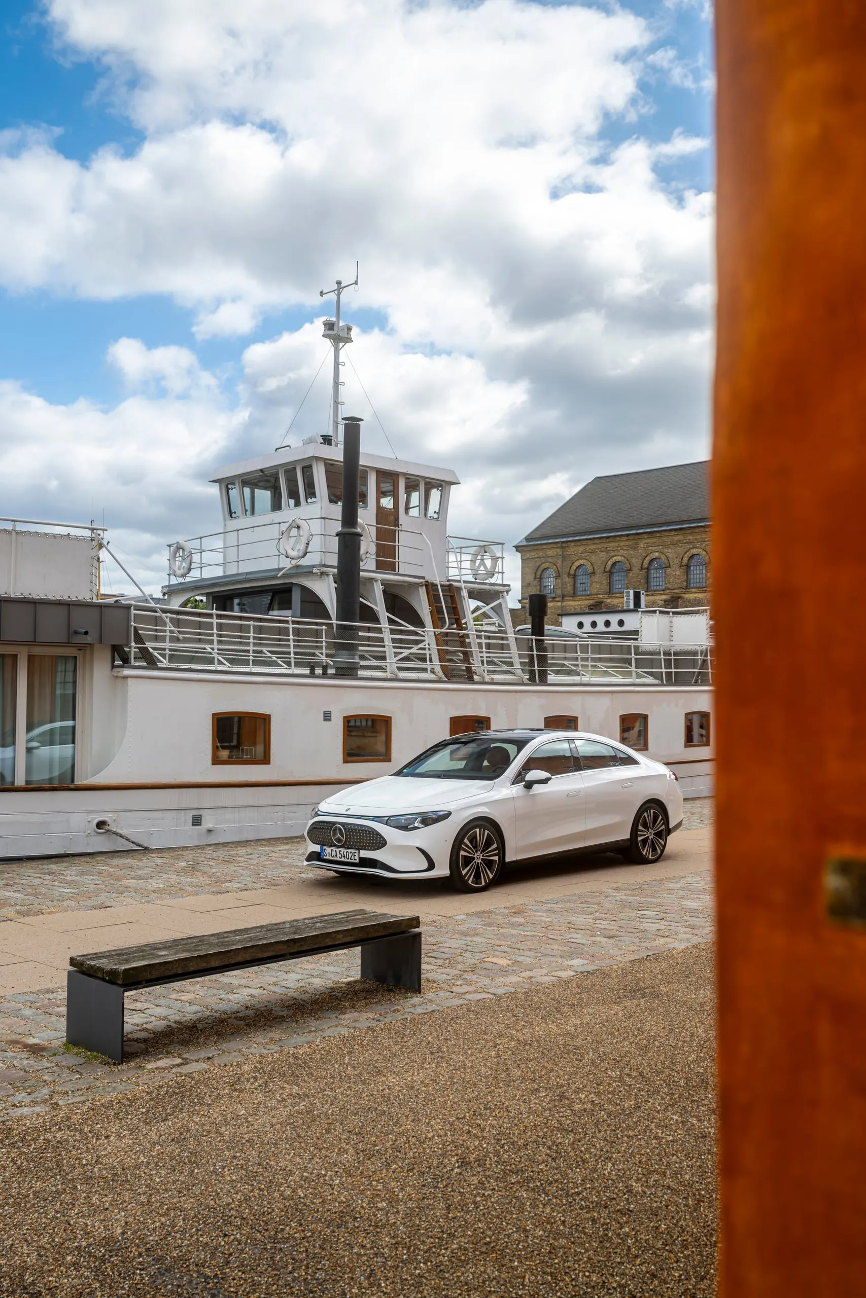 Weißer CLA vor einem Schiff im Hafen