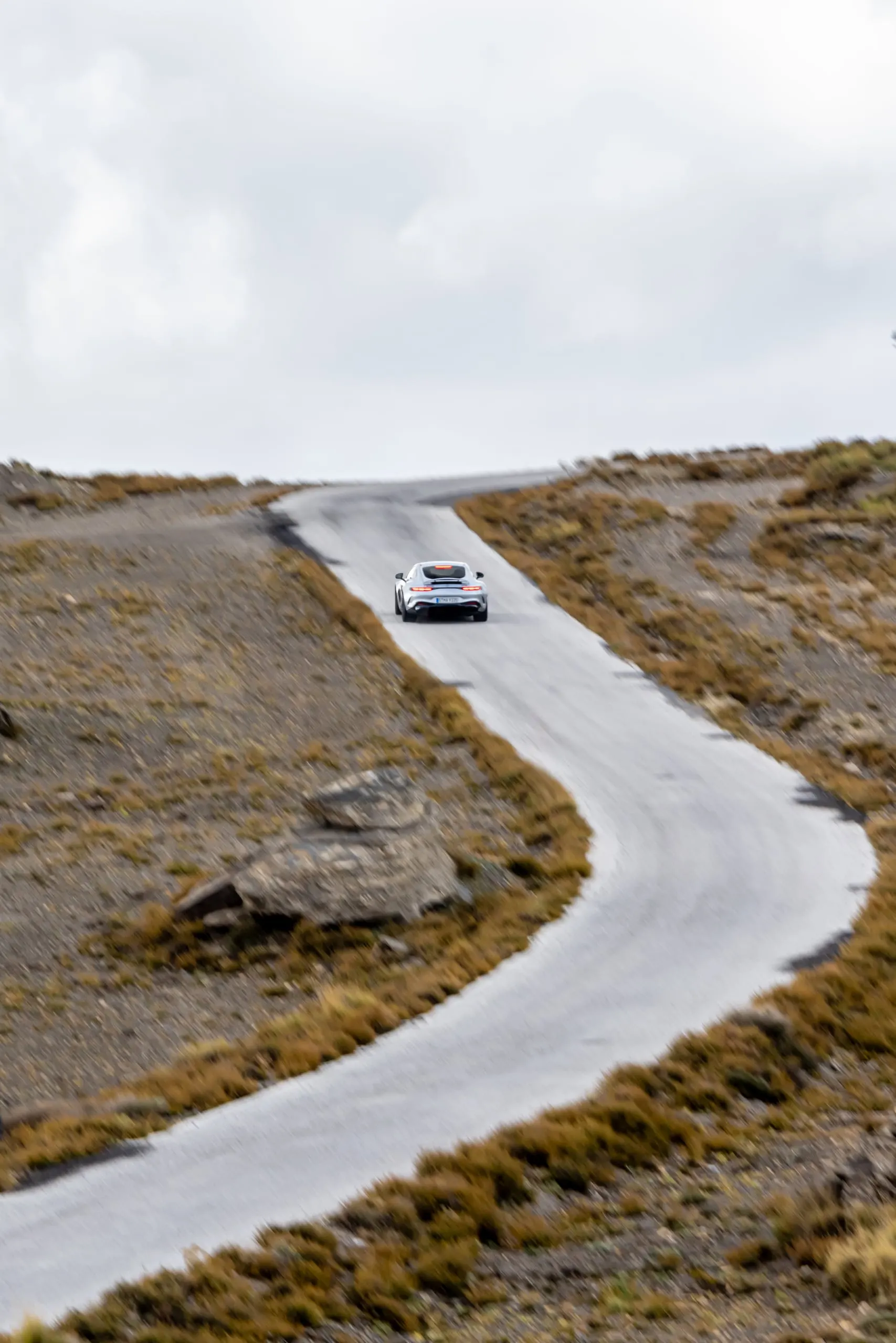 AMG GT auf einer geschwungenen Bergstraße, von oben fotografiert