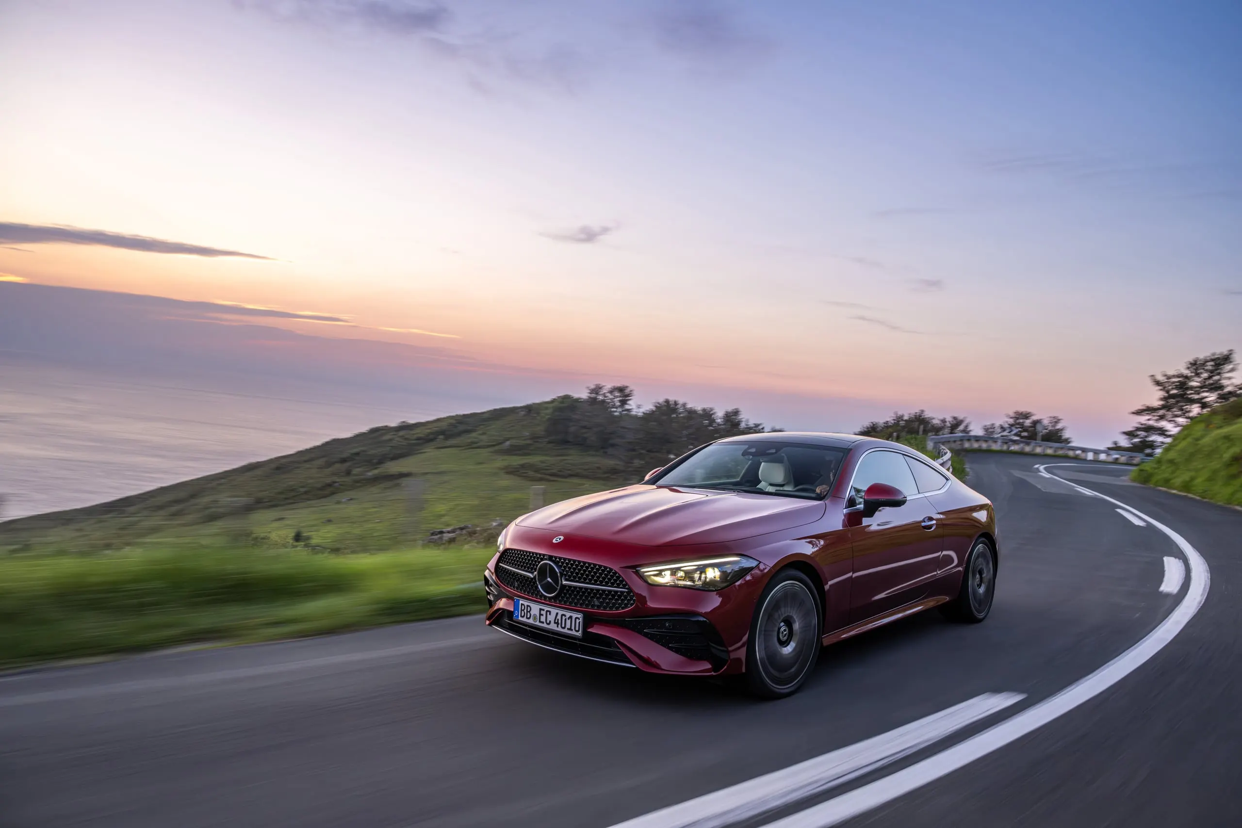 Rotes CLE Coupé in einer Kurve bei Sonnenuntergang