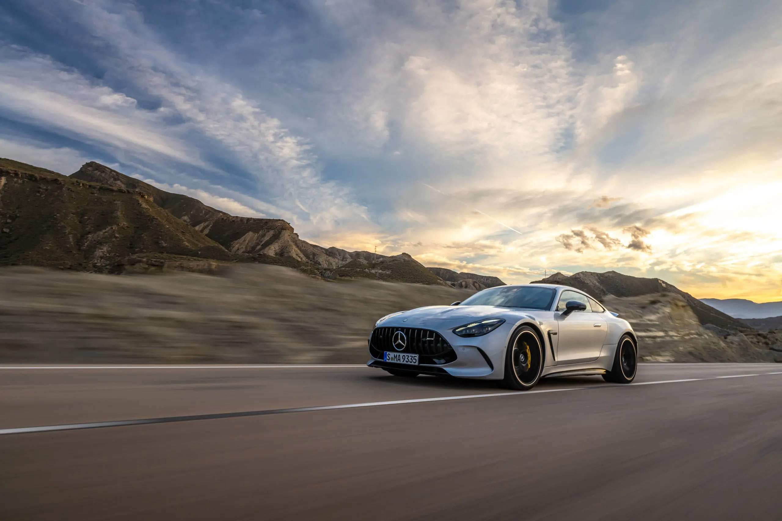 AMG GT in Fahrt auf einer Landstraße unter dramatischem Himmel
