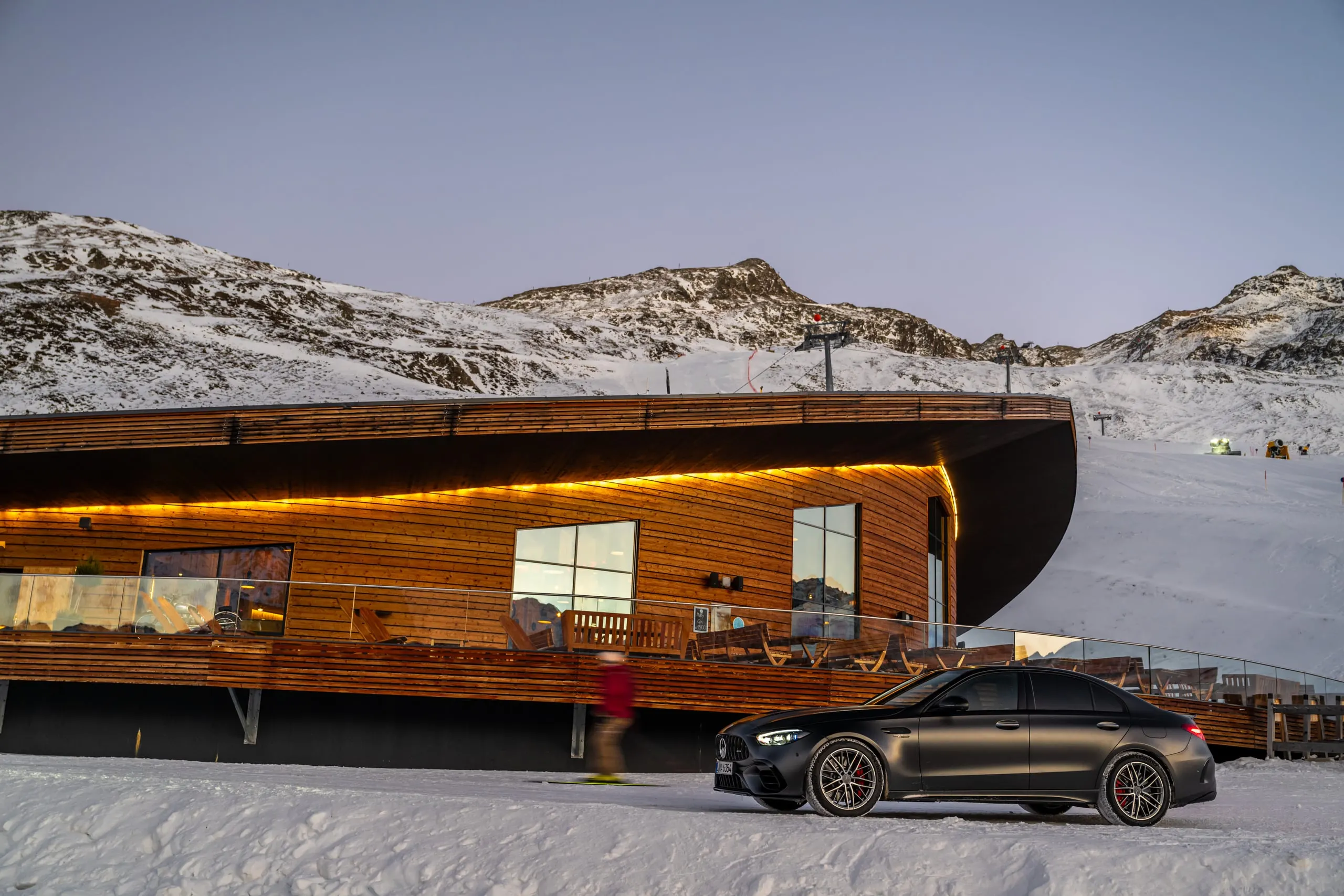 C 63 vor einem modernen Holzgebäude im Schnee