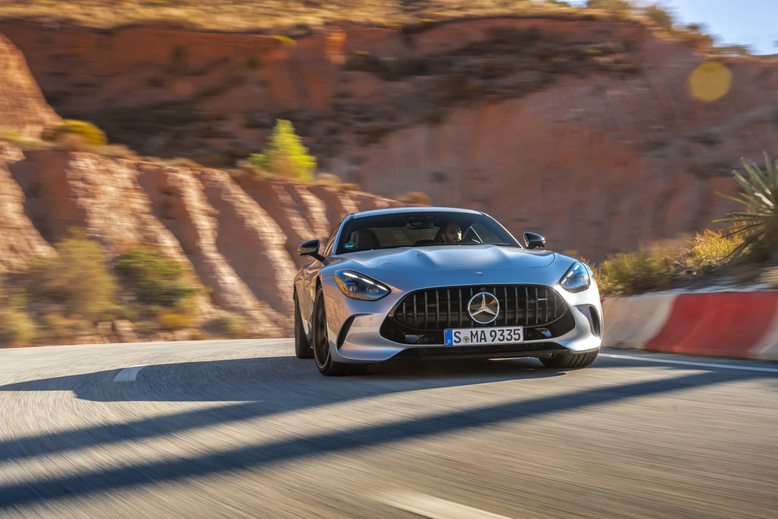 AMG GT in Frontansicht in einer Kurve vor roten Felsen