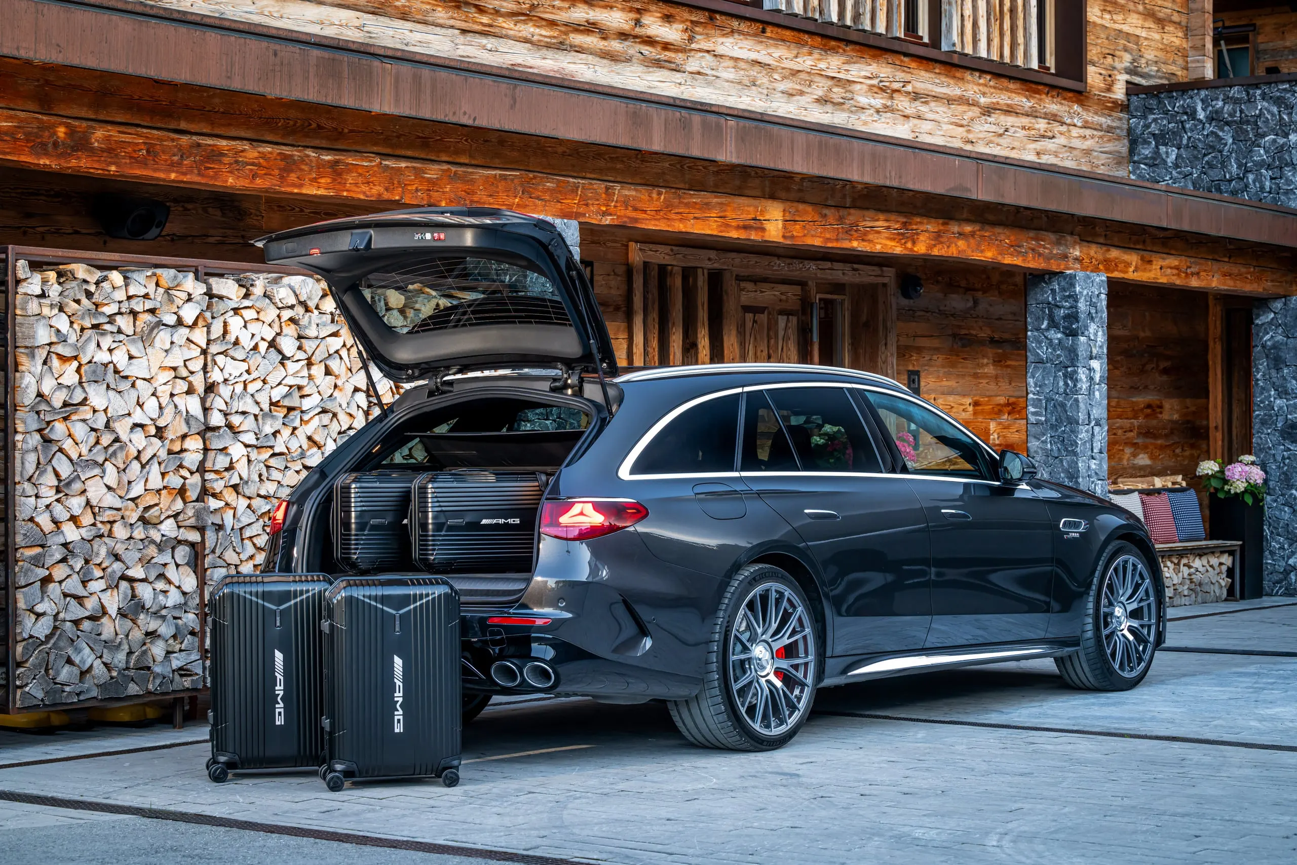 E 53 T-Modell mit geöffneter Heckklappe und Koffern vor einem Chalet