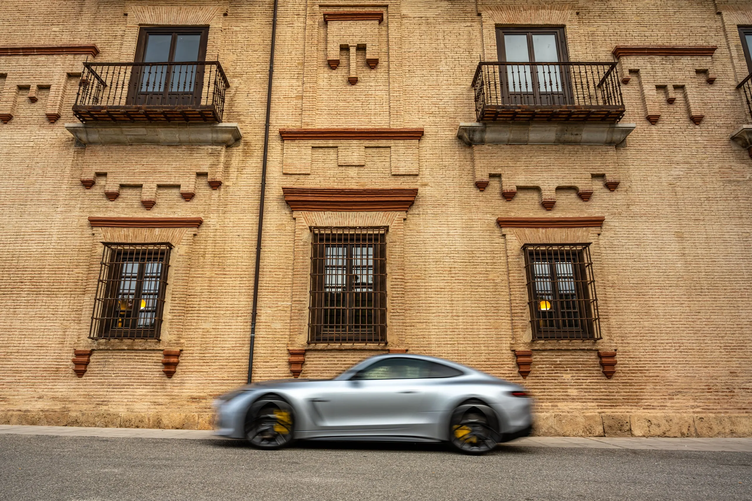 AMG GT in Fahrt vor einer verzierten Hausfassade