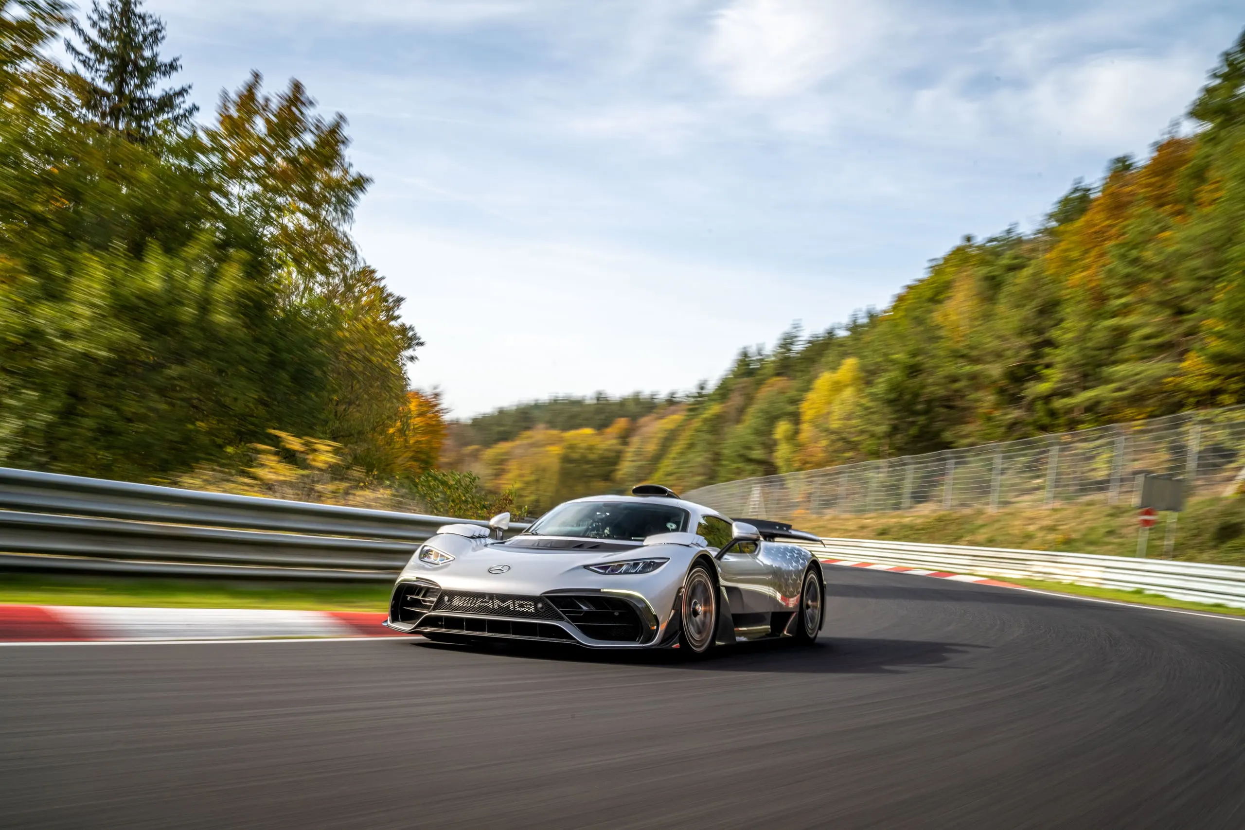 Silberner AMG ONE in einer Kurve zwischen herbstlichen Bäumen