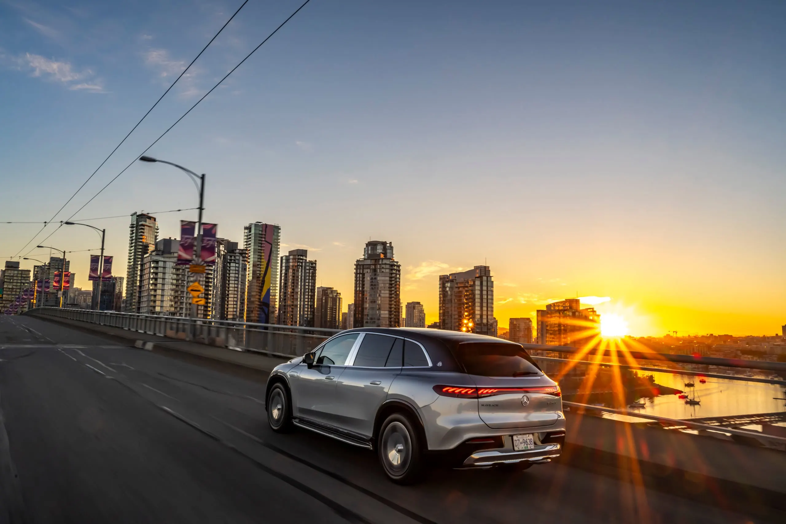 Maybach EQS SUV auf einer Brücke bei Sonnenuntergang über der Stadt