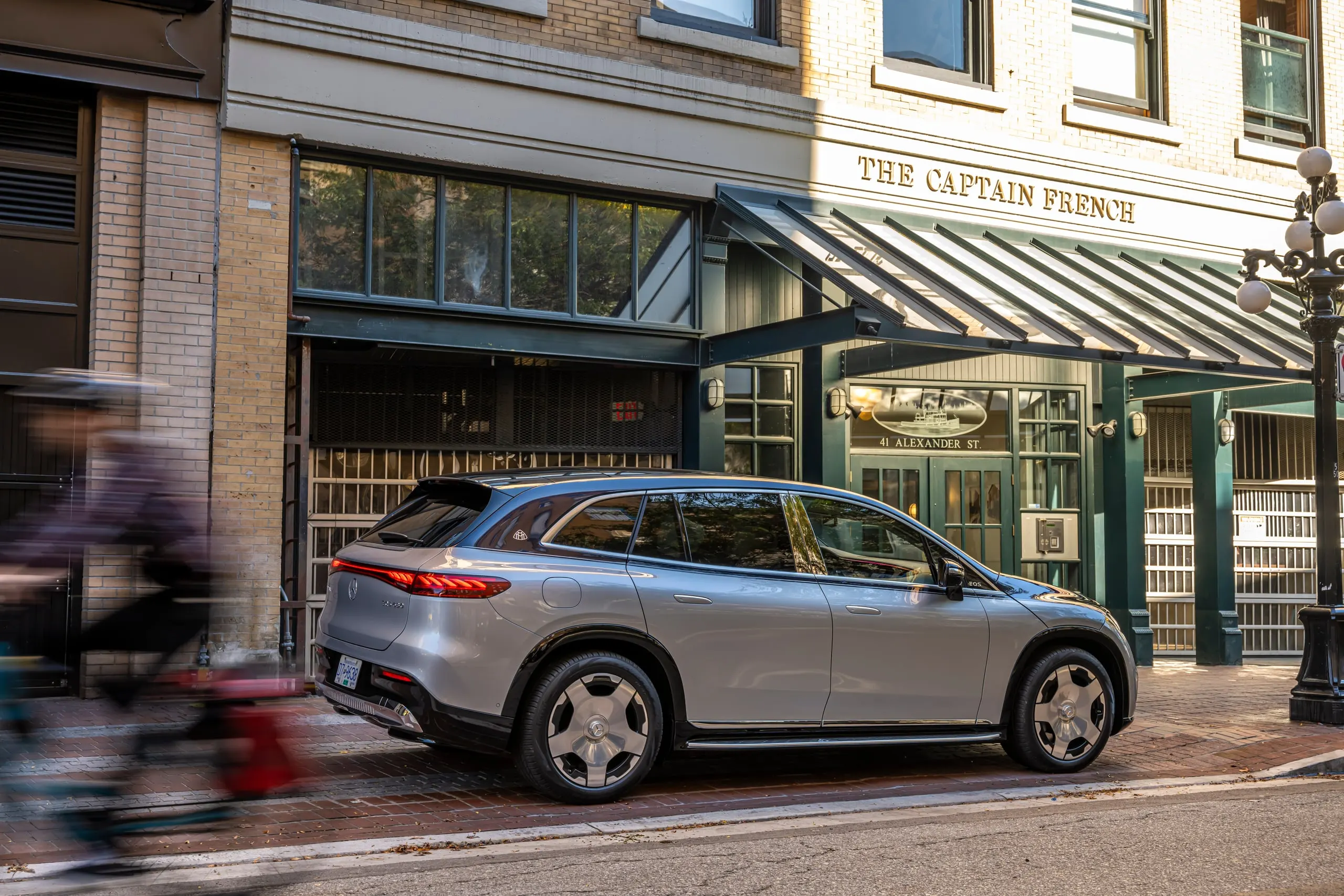 Maybach EQS SUV vor einem Hotel mit Radfahrer