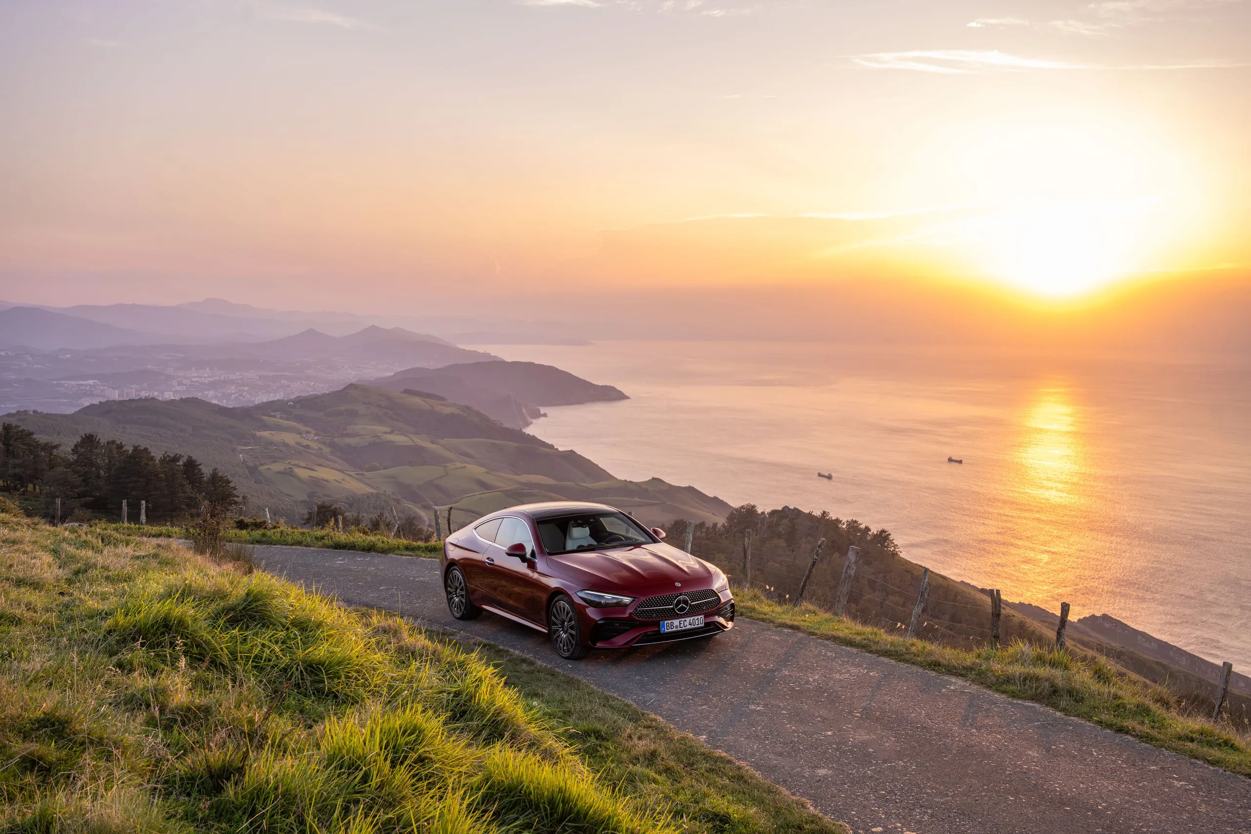 Rotes CLE Coupé über der Küste bei Sonnenuntergang