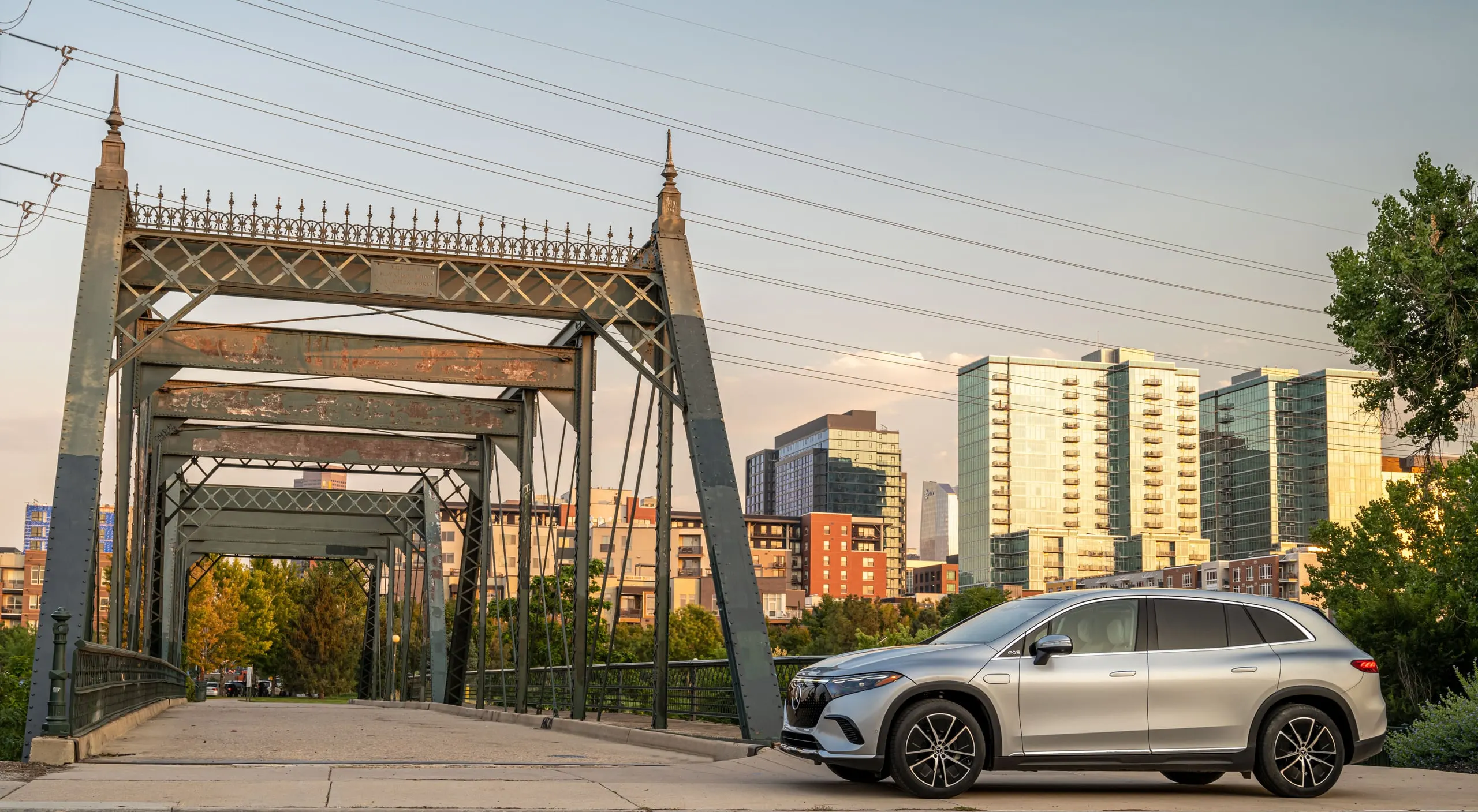EQS SUV vor einer Stahlbrücke und der Skyline