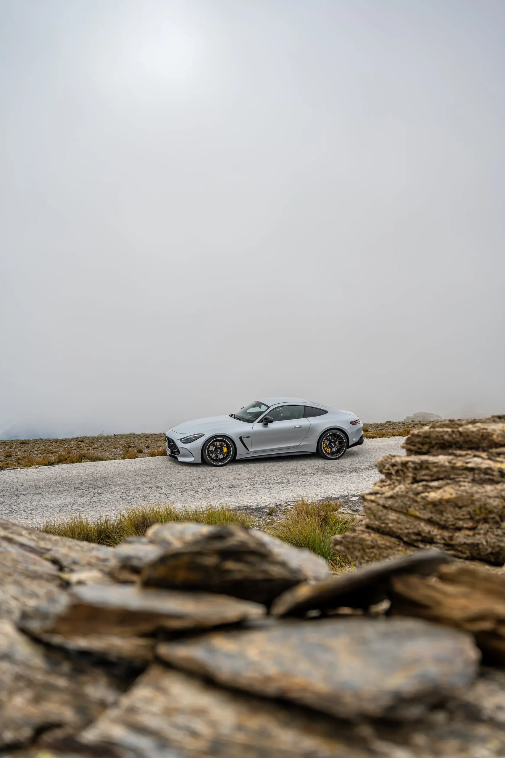AMG GT hinter Felsen im Nebel, Hochformat