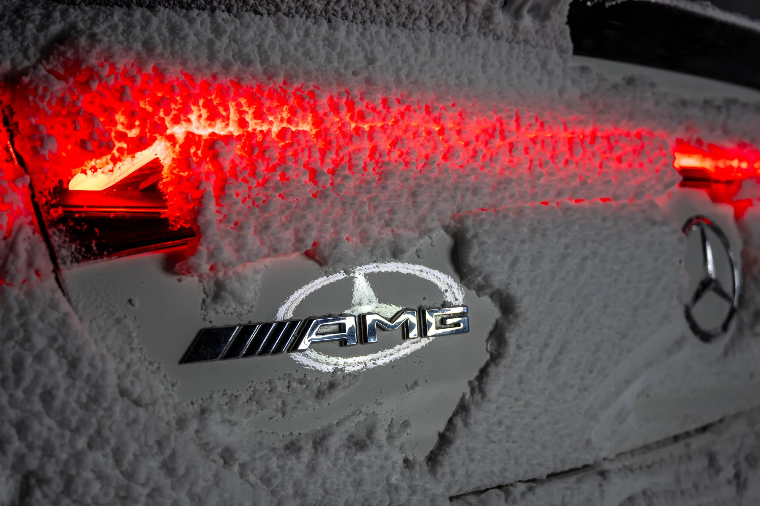 Verschneites AMG-Emblem an der Heckleuchte