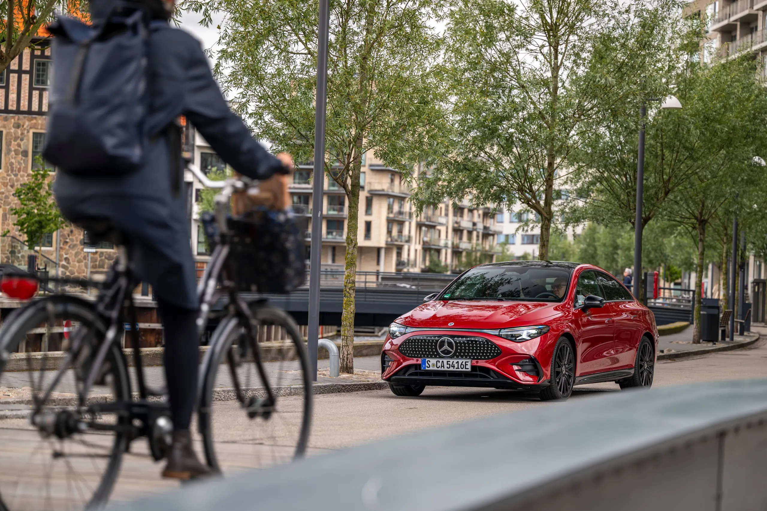 Radfahrer fährt am roten CLA vorbei