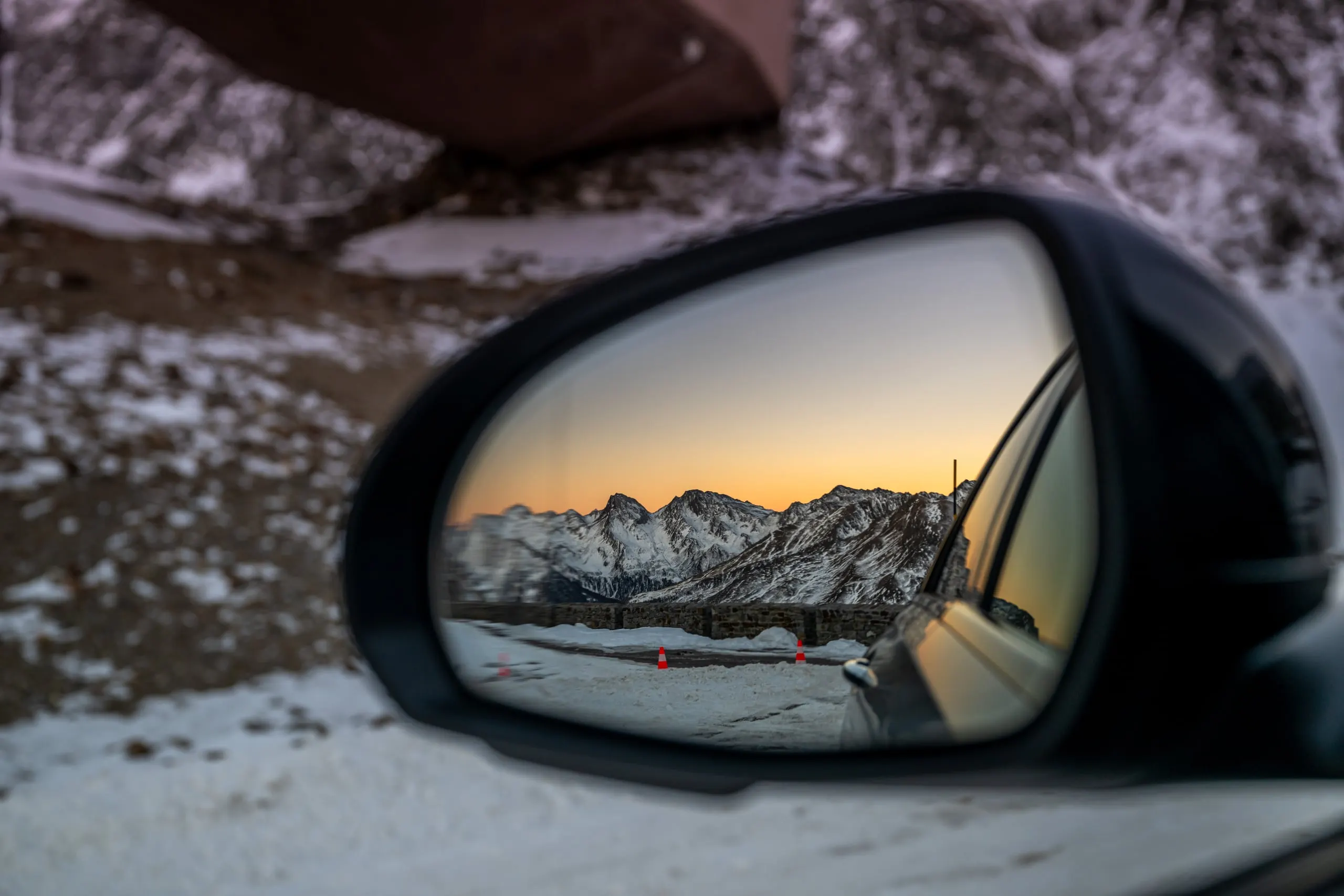 Außenspiegel mit Bergpanorama bei Sonnenuntergang