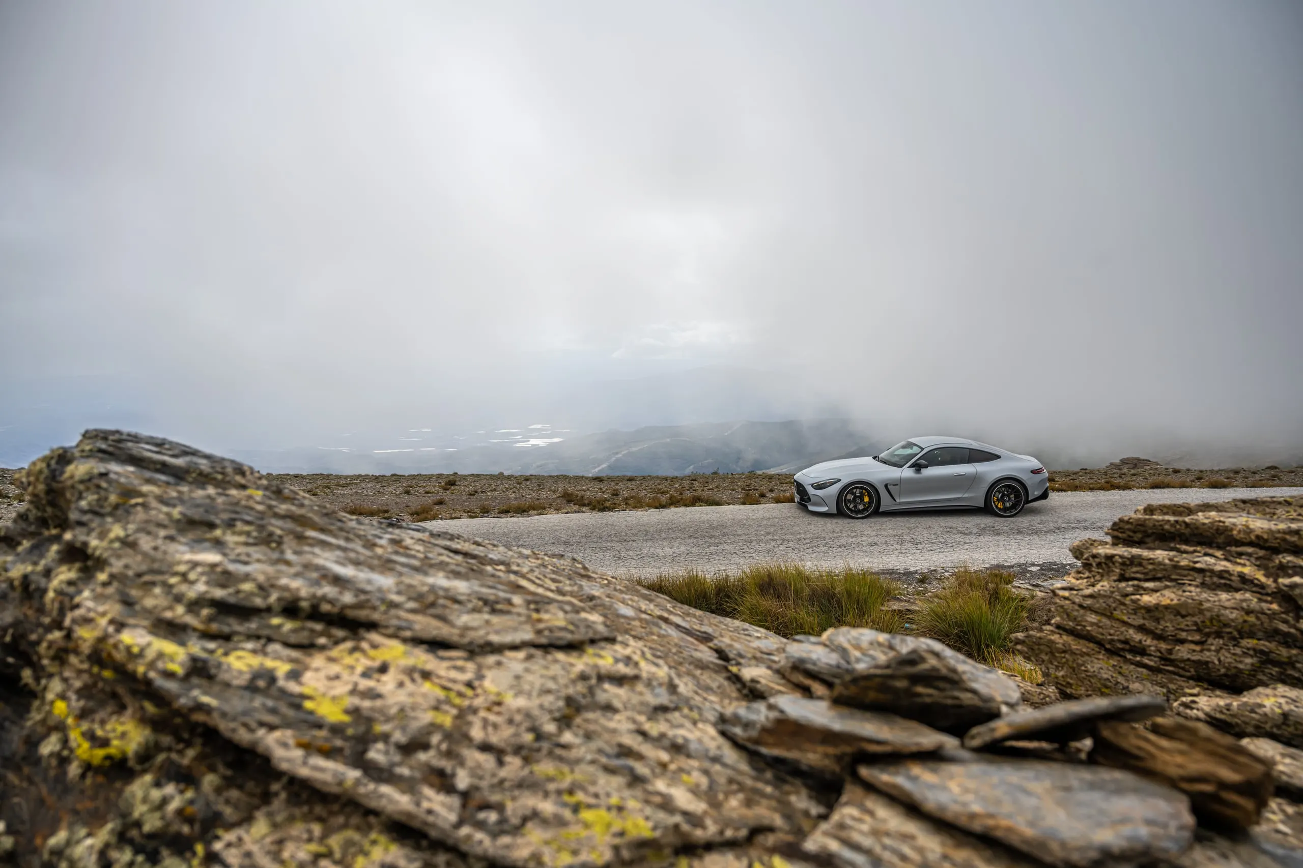 AMG GT hinter einer Felskante auf einer Bergstraße