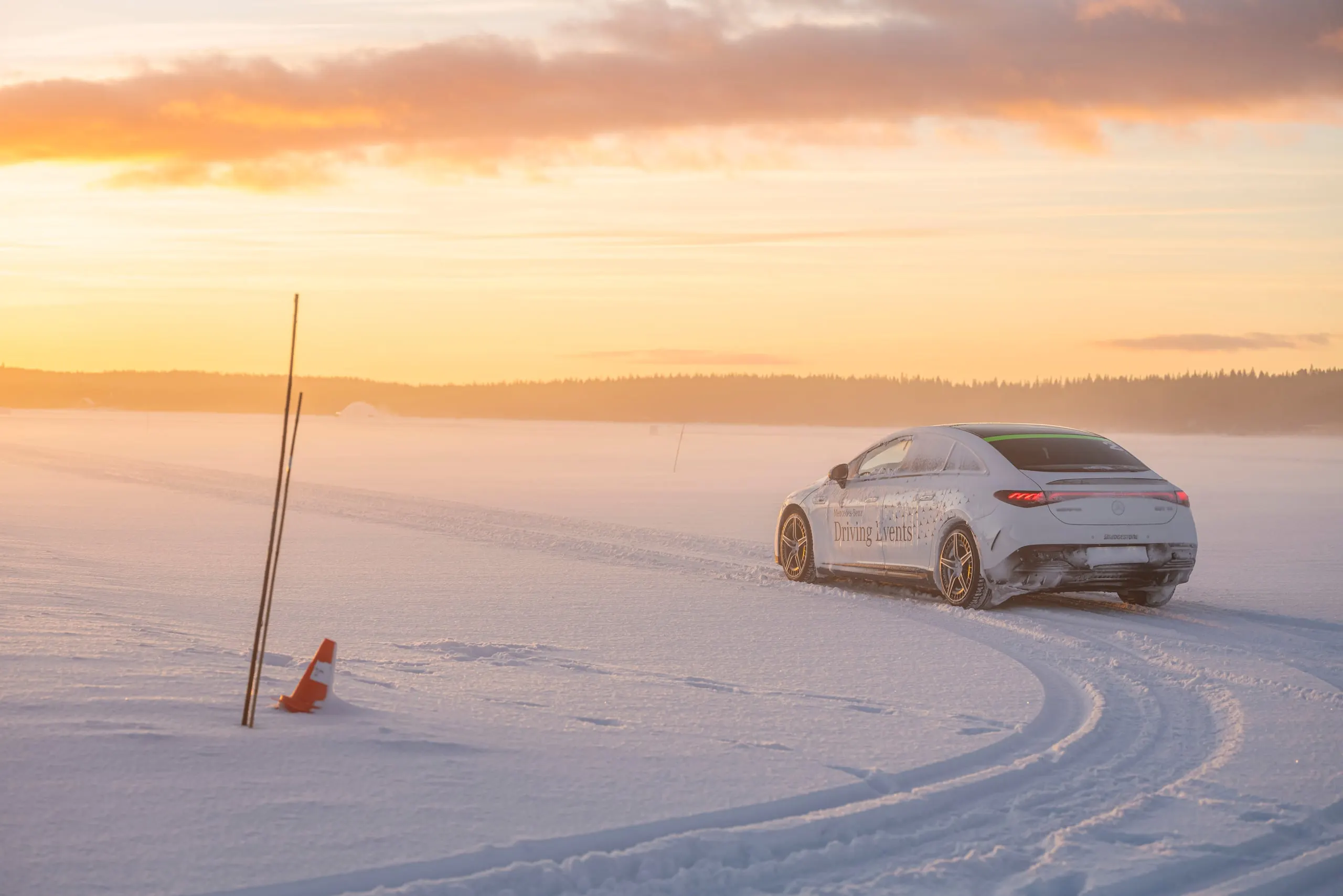 Fahrzeug auf dem Schneeparcours bei Sonnenuntergang